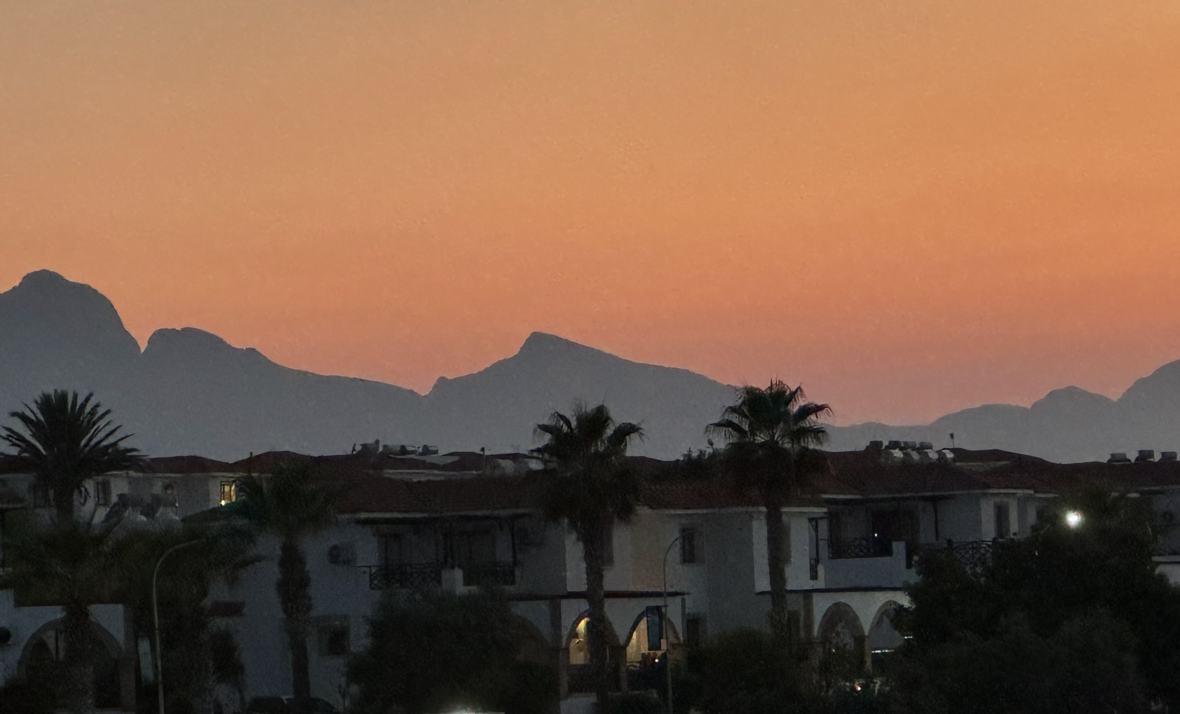 Apartmentanlage in Esentepe mit Palmen in der Abenddämmerung vor dem Kyrenia-Gebirge