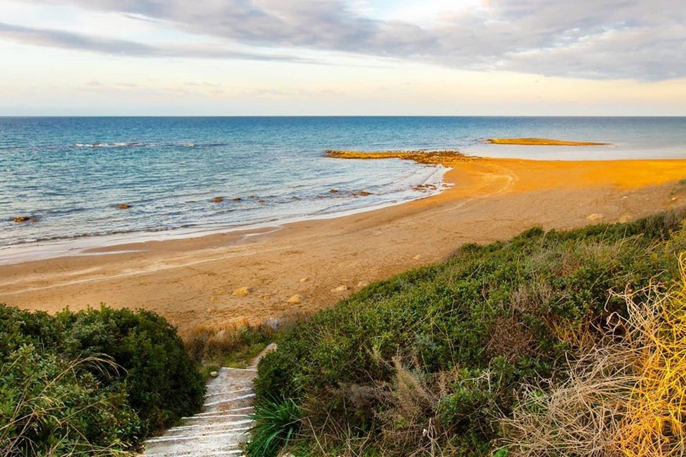 Goldener Sandstrand mit Dünenpfad und klarem Meer